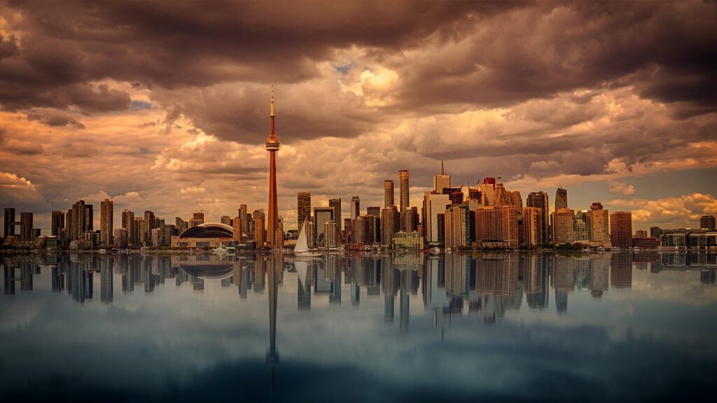 Toronto skyline at sunset reflected in water - representing newcomer life in Canada